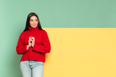 young pretty woman feeling proud, mischievous and arrogant while scheming an evil plan or thinking of a trick. copy space to place your concept