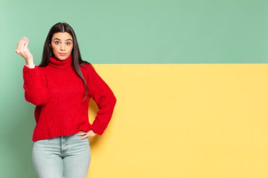 young pretty woman making capice or money gesture, telling you to pay your debts!. copy space to place your concept