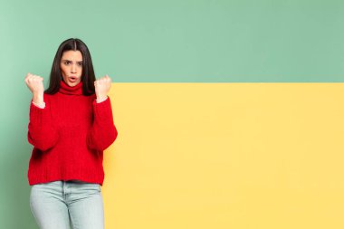 young pretty woman celebrating an unbelievable success like a winner, looking excited and happy saying take that!. copy space to place your concept