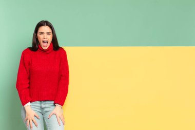 young pretty woman shouting aggressively, looking very angry, frustrated, outraged or annoyed, screaming no. copy space to place your concept