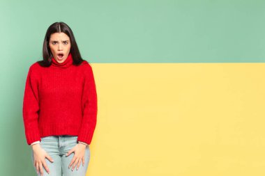 young pretty woman looking shocked, angry, annoyed or disappointed, open mouthed and furious. copy space to place your concept