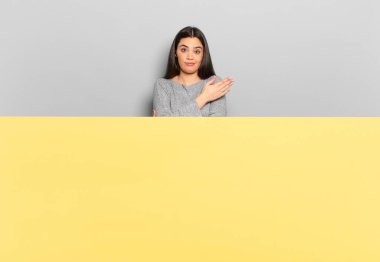 young pretty woman feeling confused and clueless, wondering about a doubtful explanation or thought. copy space to place your concept