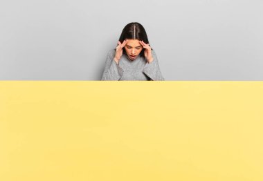 young pretty woman looking stressed and frustrated, working under pressure with a headache and troubled with problems. copy space to place your concept