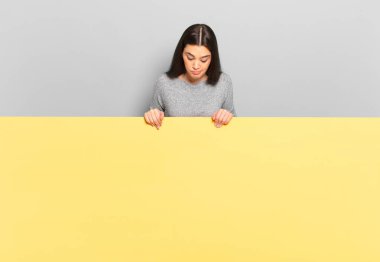 young pretty woman wondering, thinking happy thoughts and ideas, daydreaming, looking to copy space on side. copy space to place your concept