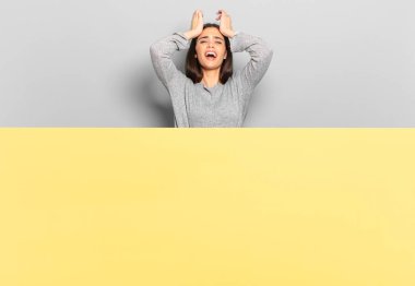 young pretty woman feeling stressed and anxious, depressed and frustrated with a headache, raising both hands to head. copy space to place your concept