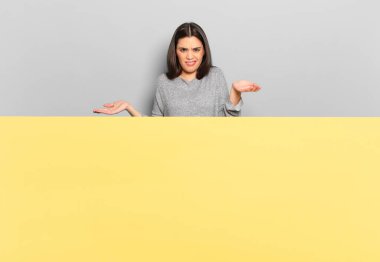 young pretty woman feeling clueless and confused, not sure which choice or option to pick, wondering. copy space to place your concept