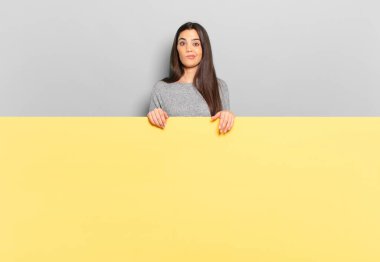 young pretty woman feeling confused and doubtful, wondering or trying to choose or make a decision. copy space to place your concept