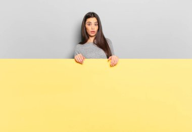 young pretty woman feeling puzzled and confused, with a dumb, stunned expression looking at something unexpected. copy space to place your concept