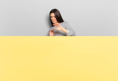 young pretty woman feeling disgusted and nauseous, backing away from something nasty, smelly or stinky, saying yuck. copy space to place your concept