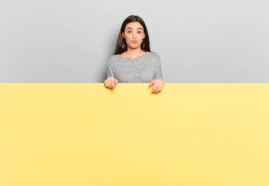 young pretty woman pressing lips together with a cute, fun, happy, lovely expression, sending a kiss. copy space to place your concept