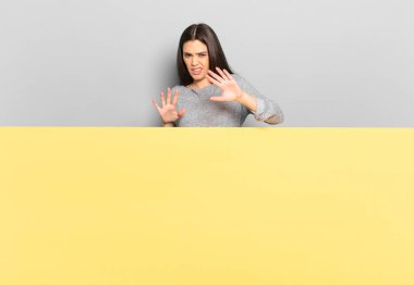 young pretty woman feeling terrified, backing off and screaming in horror and panic, reacting to a nightmare. copy space to place your concept