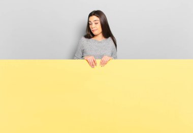 young pretty woman feeling clueless, confused and uncertain about which option to pick, trying to solve the problem. copy space to place your concept