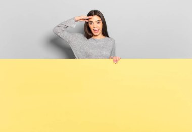 young pretty woman greeting the camera with a military salute in an act of honor and patriotism, showing respect. copy space to place your concept