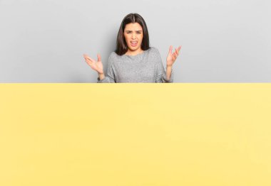 young pretty woman feeling extremely shocked and surprised, anxious and panicking, with a stressed and horrified look. copy space to place your concept