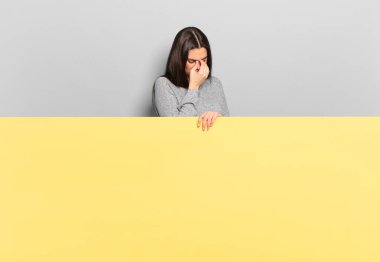 young pretty woman feeling stressed, unhappy and frustrated, touching forehead and suffering migraine of severe headache. copy space to place your concept