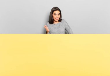 young pretty woman smiling, looking happy, confident and friendly, offering a handshake to close a deal, cooperating. copy space to place your concept