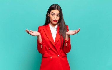 young pretty woman feeling puzzled and confused, doubting, weighting or choosing different options with funny expression. business concept