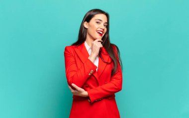 young pretty woman smiling with a happy, confident expression with hand on chin, wondering and looking to the side. business concept