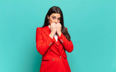 young pretty woman looking worried, anxious, stressed and afraid, biting fingernails and looking to lateral copy space. business concept