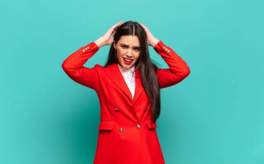 young pretty woman feeling stressed, worried, anxious or scared, with hands on head, panicking at mistake. business concept