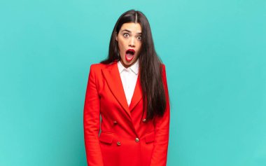 young pretty woman looking very shocked or surprised, staring with open mouth saying wow. business concept