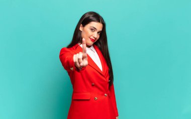 young pretty woman smiling proudly and confidently making number one pose triumphantly, feeling like a leader. business concept