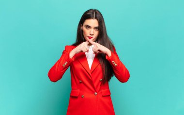 young pretty woman looking serious and displeased with both fingers crossed up front in rejection, asking for silence. business concept