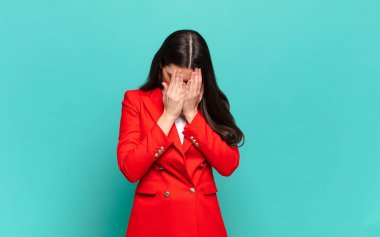 young pretty woman feeling sad, frustrated, nervous and depressed, covering face with both hands, crying. business concept