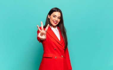 young pretty woman smiling and looking friendly, showing number three or third with hand forward, counting down. business concept