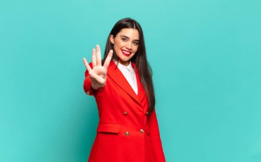 young pretty woman smiling and looking friendly, showing number four or fourth with hand forward, counting down. business concept