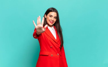 young pretty woman smiling and looking friendly, showing number five or fifth with hand forward, counting down. business concept