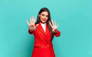 young pretty woman smiling and looking friendly, showing number nine or ninth with hand forward, counting down. business concept