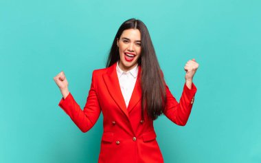 young pretty woman looking extremely happy and surprised, celebrating success, shouting and jumping. business concept