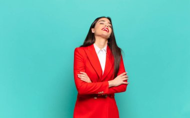 young pretty woman laughing happily with arms crossed, with a relaxed, positive and satisfied pose. business concept