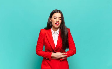 young pretty woman feeling anxious, ill, sick and unhappy, suffering a painful stomach ache or flu. business concept