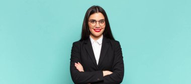 young pretty woman looking like a happy, proud and satisfied achiever smiling with arms crossed. business concept