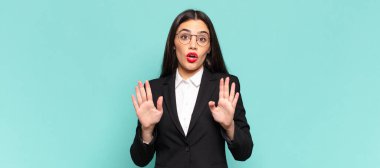 young pretty woman looking nervous, anxious and concerned, saying not my fault or I didnt do it. business concept 