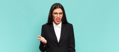 young pretty woman looking angry, annoyed and frustrated screaming wtf or whats wrong with you. business concept 