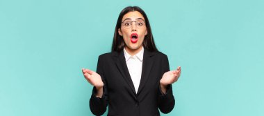 young pretty woman open-mouthed and amazed, shocked and astonished with an unbelievable surprise. business concept