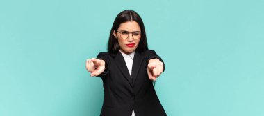 young pretty woman pointing forward at camera with both fingers and angry expression, telling you to do your duty. business concept