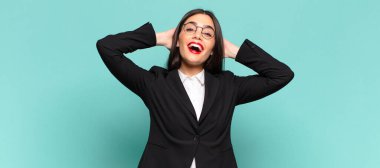 young pretty woman looking happy, carefree, friendly and relaxed enjoying life and success, with a positive attitude. business concept