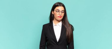 young pretty woman wondering, thinking happy thoughts and ideas, daydreaming, looking to copy space on side. business concept