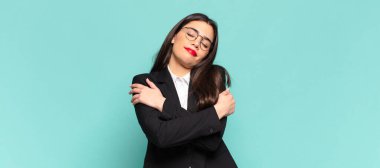 young pretty woman feeling in love, smiling, cuddling and hugging self, staying single, being selfish and egocentric. business concept