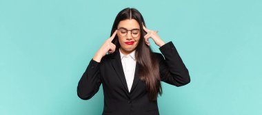 young pretty woman looking concentrated and thinking hard on an idea, imagining a solution to a challenge or problem. business concept