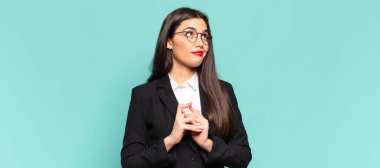 young pretty woman scheming and conspiring, thinking devious tricks and cheats, cunning and betraying. business concept