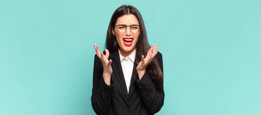 young pretty woman looking desperate and frustrated, stressed, unhappy and annoyed, shouting and screaming. business concept