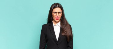 young pretty woman feeling puzzled and confused, with a dumb, stunned expression looking at something unexpected. business concept