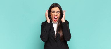 Genç ve güzel bir kadın ellerini havaya kaldırıp bağırıyor. Öfkeli, sinirli, stresli ve üzgün hissediyor. iş kavramı