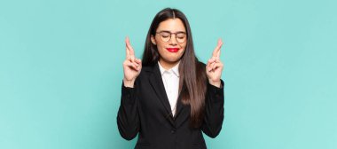 Genç ve güzel bir kadın gergin ve umutlu, dua ediyor ve iyi şanslar diliyor. iş kavramı