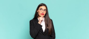 Genç, güzel bir kadın düşünüyor, kuşkulu ve şaşkın hissediyor, farklı seçeneklerle, hangi kararı vereceğini merak ediyor. iş kavramı